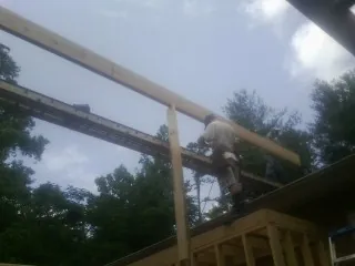 Carpenter setting a ridge beam over a new addition frame — Ice Dam Removal by Roofing Brothers in Porterdale