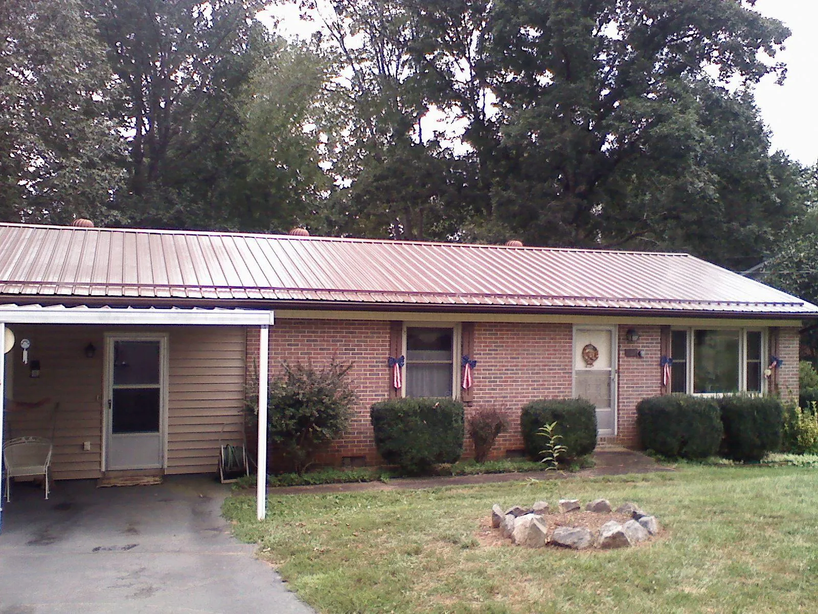 Bronze metal roof and carport on a brick ranch home — Roof Repair work by our crew in Porterdale